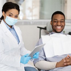 Happy dental patient next to dental team member