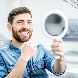 Man in dentist’s chair with blue shirt smiling