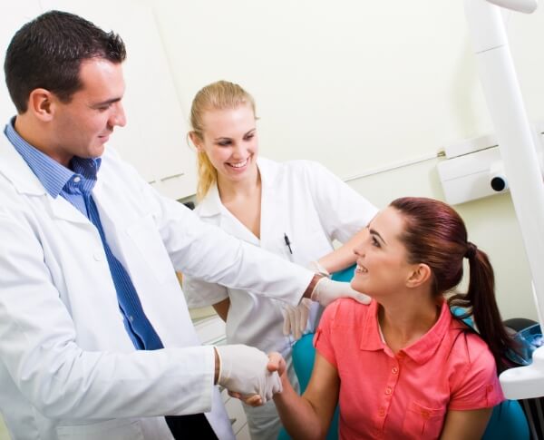 Oral surgeon shaking hands with patient