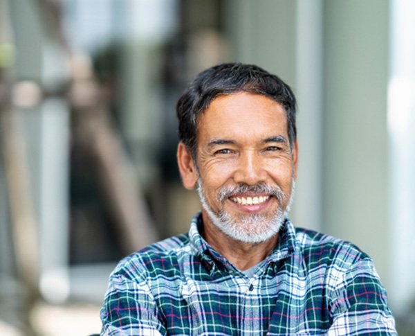 Man smiling after getting dental implants in Coppell, TX