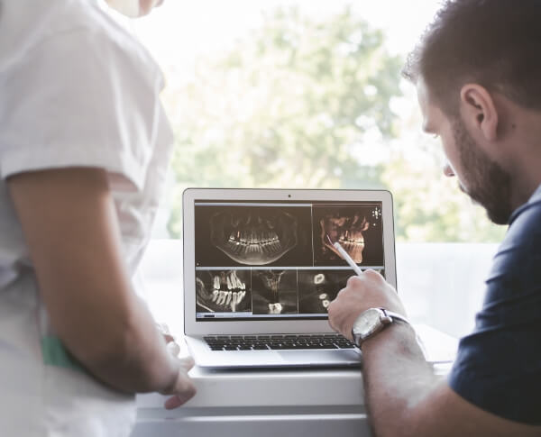 Dentist and patient looking at digital x-rays