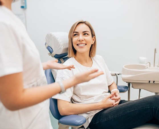 a dental patient smiling while visiting her dentist