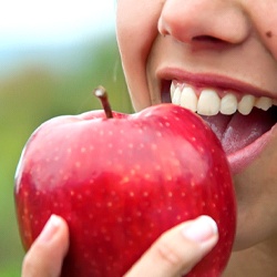 Close up of woman biting into red apple