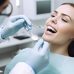 Female patient has mouth checked by dentist