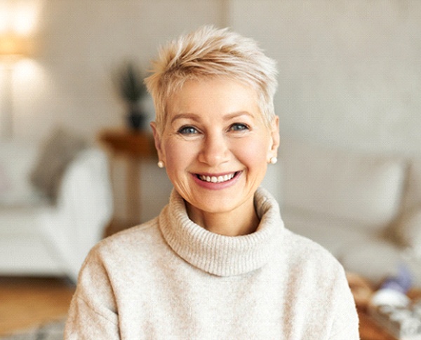 Woman with short hair smiling in sweater