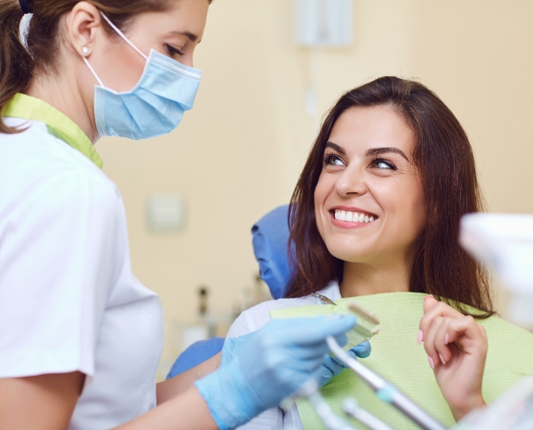 Woman and oral surgery team member discussing the cost of dental implants