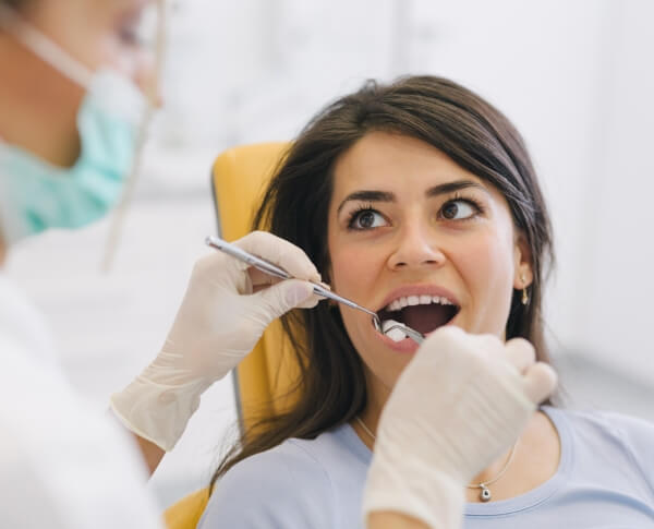 Woman receiving wisdom tooth extractions during oral surgery visit