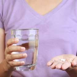 person taking pills for dental implant post-op instructions in Coppell