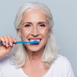  woman brushing for dental implant post-op instructions in Coppell