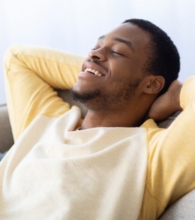 man leaning back in chair smiling