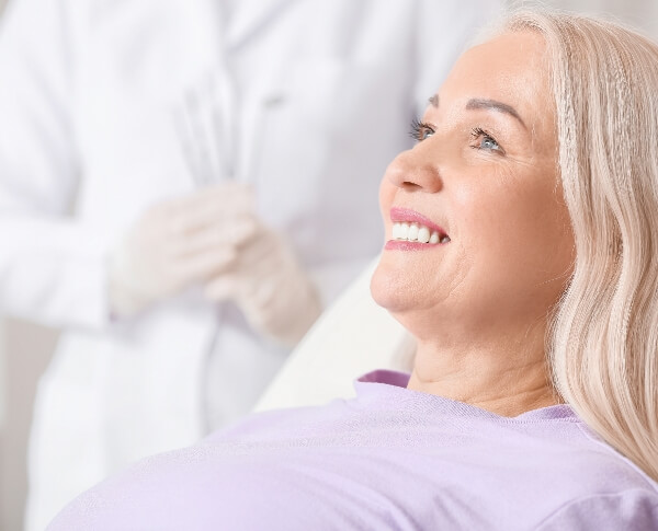 Woman smiling after receiving a robot assisted dental implant