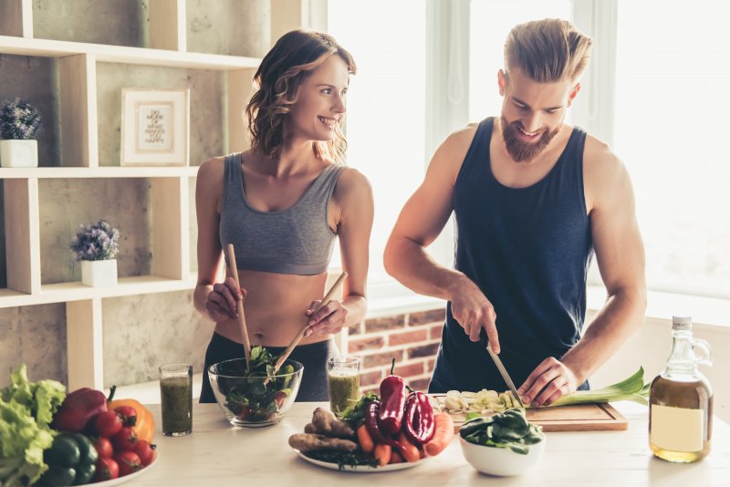 A couple preparing a healthy meal to support their dental implants