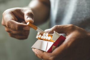 Man taking cigarette out of pack. 