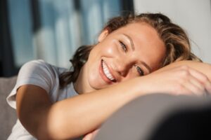 Woman sitting on couch smiling. 