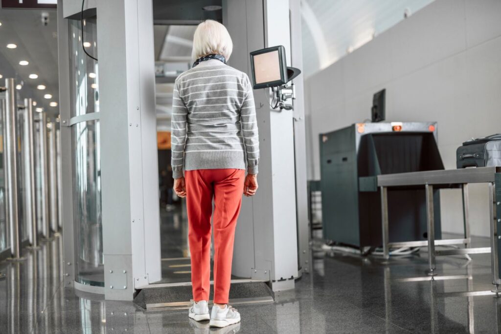 A woman walking through a metal detector at the airport